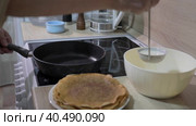 A man pours dough into a deep frying pan. Cooking pancakes at home. Стоковое видео, видеограф Юрий Поздников / Фотобанк Лори
