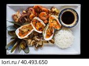 Sautéed seafood on white plate close up isolated on black background top view. Стоковое фото, фотограф Татьяна Терехина / Фотобанк Лори