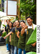 Vietnamese coffee shop team smiling and standing together against a cafe. Стоковое фото, фотограф Татьяна Терехина / Фотобанк Лори