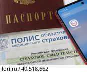 Персональные данные гражданина РФ: паспорт, медицинский полис, СНИЛС и телефон с электронным приложением Государственные слуги (2023 год). Редакционное фото, фотограф Татьяна Т / Фотобанк Лори
