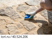 A man makes a path of stones at their summer cottage. Grouting the surface of the track with sand. Стоковое фото, фотограф Коханова Наталья / Фотобанк Лори