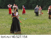 Russian folk traditions. Folk festivals. Children in beautiful Russian traditional outfits sing songs, dance and lead a round dance in Tsaritsyno Park. National Russian clothes. Sundresses and kokoshniks. (2023 год). Редакционное фото, фотограф Photojuli / Фотобанк Лори