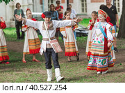 Russian folk traditions. Folk festivals. Children in beautiful Russian traditional outfits sing songs, dance and lead a round dance in Tsaritsyno Park. National Russian clothes. Sundresses and kokoshniks. (2023 год). Редакционное фото, фотограф Photojuli / Фотобанк Лори