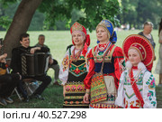 Russian folk traditions. Folk festivals. Children in beautiful Russian traditional outfits sing songs, dance and lead a round dance in Tsaritsyno Park. National Russian clothes. Sundresses and kokoshniks. (2023 год). Редакционное фото, фотограф Photojuli / Фотобанк Лори