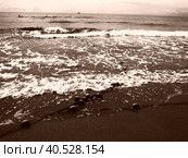 Buoys on a rope near sea water. The buoys are bright pink restraints to alert people to the depth of the water. Sepia. Delimiting a place on a sandy beach between hotels. Waves with bubbles. Стоковое фото, фотограф Юлия Петровская / Фотобанк Лори