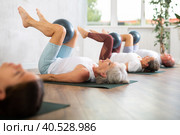 People lying on karemat, pulled bent legs to themselves and clamped soft-ball in knee. Стоковое фото, фотограф Яков Филимонов / Фотобанк Лори