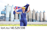 Cheerful female worker in hardhat with australian flag standing in front of factory Happy girl in work clothes and hardhat with flag of australia standing in front of industrial scenery woman. Стоковое видео, видеограф Яков Филимонов / Фотобанк Лори