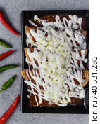 Chilaquiles with chicken and sour cream and sauce with many vegetables on a gray background. Стоковое фото, фотограф Татьяна Терехина / Фотобанк Лори