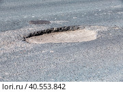 Large pothole an example of poor road maintenance. Стоковое фото, фотограф FotograFF / Фотобанк Лори