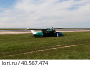 Россия, Калмыкия. 04.20.2019: Легкомоторный самолет Cessna 182 Skylane стоит в степи на берегу озера, рядом с туристическими палатками. Редакционное фото, фотограф Ольга Шуклина / Фотобанк Лори