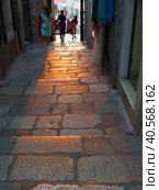 Herceg Novi, Montenegro, old town, Sat-kula tower, Sahat-kula, Tora, chapel tower or Clock tower 08.10.22 Tourists walk along the aisle under the city clock. Sunset, golden hour, summer evening. (2022 год). Редакционное фото, фотограф Юлия Петровская / Фотобанк Лори