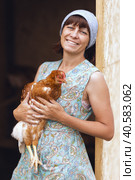 A woman in the village, in a chicken coop, takes care of poultry chickens. Private poultry farm. Стоковое фото, фотограф Анатолий Типляшин / Фотобанк Лори