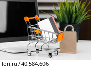 Online shopping concept. Shopping cart, laptop on the desk. Стоковое фото, фотограф Сергей Толмачёв / Фотобанк Лори