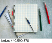 Open notebooks are fan-folded on top of each other. On top are the pens. Nearby are colored markers. You can write text on a blank sheet. Education concept. Стоковое фото, фотограф Бузмакова Светлана / Фотобанк Лори