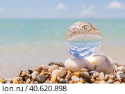 Glass round ball on the beach reflects the sea in summer. Стоковое фото, фотограф Виктория Подгорная / Фотобанк Лори