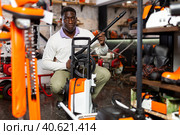 Considerate customer chooses washer at garden tool store. Стоковое фото, фотограф Яков Филимонов / Фотобанк Лори