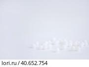 Homeopathic globules scattered on a white background. Alternative Homeopathy medicine herbs, health care and pills concept. copy space. Стоковое фото, фотограф Tatiana Syrtseva / Фотобанк Лори