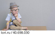 portrait brooding thoughtful preschool boy kid sitting in hat and glasses school. Стоковое видео, видеограф Olesia Kondrateva / Фотобанк Лори