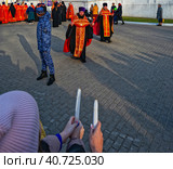 Пасха. Священник несет прихожанам благодатный огонь около около Успенского собора. Город Владимир (2023 год). Редакционное фото, фотограф Макаров Алексей / Фотобанк Лори