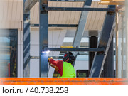 A man-welder fastens iron girders with a welding machine. Construction of the station. Стоковое фото, фотограф Юрий Поздников / Фотобанк Лори