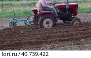 Small tractor with plow attachment plows soil in potato field before spring sowing. Стоковое видео, видеограф Владимир Григорьев / Фотобанк Лори