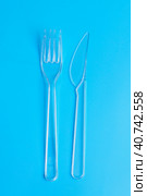 Plastic disposable tableware, cutlery. Fast food. Clean plastic fork and knive on blue background. Стоковое фото, фотограф Tatiana Syrtseva / Фотобанк Лори