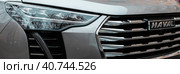 Detail of Haval Jolion car. headlight and logo on radiator front grill (2022 год). Редакционное фото, фотограф Константин Григорьев / Фотобанк Лори