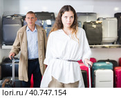 Happy woman chose suitcase in haberdashery store. Стоковое фото, фотограф Яков Филимонов / Фотобанк Лори