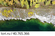 A lake with clear turquoise water. A path along the rocky coast in autumn. View from above. Озеро с прозрачной бирюзовой водой. Тропинка вдоль скалистого побережья осенью. Стоковое видео, видеограф Виктория Тельминова / Фотобанк Лори