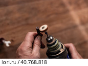 Restoration of an old Nagan revolver bullet case with a grinding machine. War finds of the early 20th century. Стоковое фото, фотограф Коханова Наталья / Фотобанк Лори
