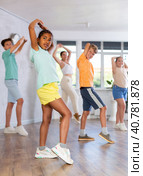 Energetic african american tween girl practicing vigorous dance in group class. Стоковое фото, фотограф Яков Филимонов / Фотобанк Лори