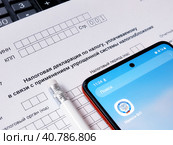 Упрощенная система налогообложения. Налоговая декларация, электронное приложение "Налоги" и карандаш. Редакционное фото, фотограф Татьяна Т / Фотобанк Лори