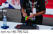 Moscow, Russia - July 1, 2023. A boy collects the Rubik's pyramid at speed at a sporting event in Luzhniki. Редакционное видео, видеограф Елена Смыкова / Фотобанк Лори