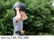 A cheerful little boy rides a running bike in a helmet outdoors. A happy child is engaged in an active sport. Protection. Life insurance and child safety. Стоковое фото, фотограф Photojuli / Фотобанк Лори