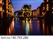 The Warehouse District - Speicherstadt in twilight. Tourism landmark of Hamburg. View of Wandrahmsfleet in light of lantern lamp. Port of Hamburg within the HafenCity quarter (2018 год). Стоковое фото, фотограф Igor Tichonow / Фотобанк Лори