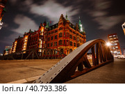 Old Speicherstadt in Hamburg illuminated at night. Arch bridge and historical buildings. Warehouse District -Speicherstadt Landmark of HafenCity quarter (2018 год). Стоковое фото, фотограф Igor Tichonow / Фотобанк Лори