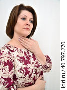 woman holds her hand on her neck - concept of diseases - tonsillitis, hyperthyroidism and others. Стоковое фото, фотограф Володина Ольга / Фотобанк Лори