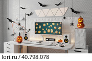 A general view of a gamer's home workplace with a computer and a gamepad decorated with decorations for the Halloween holiday. Стоковая иллюстрация, иллюстратор Енваев Андрей / Фотобанк Лори