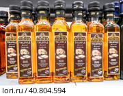 Трюфельное оливковое масло Filippo Berio в бутылках на полке в супермаркете. Оливковое масло в бутылках. Выборочный фокус (2023 год). Редакционное фото, фотограф FotograFF / Фотобанк Лори