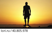 Silhouette of a man skating on a longboard at sunset. Стоковое видео, видеограф Константин Шишкин / Фотобанк Лори