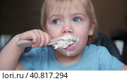 Toddler Sitting in Highchair Eating Greek Yogurt. Funny Cute Baby Eats in the Kitchen. Little Girl Learning to Eat. Child Feeding Himself by Silicone Spoon at Home. Breakfast with Dairy Products. 4K. Стоковое видео, видеограф Марина Демидюк / Фотобанк Лори