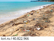 Plastic debris carried by the sea wave on the shore of a sandy beach. Waste recycling and environmental issues. Стоковое фото, фотограф Коханова Наталья / Фотобанк Лори