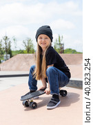 Pretty happy little girl riding on skateboard in skate park in summer day. Стоковое фото, фотограф Ирина Михайличенко / Фотобанк Лори