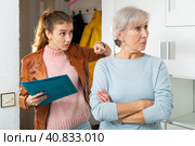 Female debt collector talking annoyed to worried elderly woman at home. Стоковое фото, фотограф Яков Филимонов / Фотобанк Лори