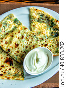 Kutabs or Gozleme - traditional Azerbaijani flatbreads with herbs and cheese. Served with sour cream. Стоковое фото, фотограф Евгений Ткачёв / Фотобанк Лори