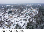 Aerial view of a snow-covered village. Winter rural landscape. Top view of the streets, houses and trees. Cold snowy winter weather. Snowfall. Snow on the roofs. Toksovo, Leningrad region, Russia. Стоковое фото, фотограф Андрей Степанов / Фотобанк Лори