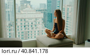 Silhouette of young woman drinking delicious coffee near window with big city outside. Relaxed girl enjoys morning cappuccino on weekend in the metropolis. Slow motion. Стоковое фото, фотограф Ольга Сухарева / Фотобанк Лори