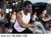 African american man in group of people working out with steppers in fitness center. Стоковое фото, фотограф Яков Филимонов / Фотобанк Лори