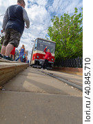 Visitors to the exhibition of old trams are photographed against the background of exhibits on the street (2023 год). Редакционное фото, фотограф Ярославский Максим / Фотобанк Лори