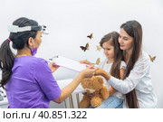 Mom and her infant daughter at the doctor's appointment. Healthy lifestyle concept. The doctor fills out the health questionnaire. Стоковое фото, фотограф Ирина Михайличенко / Фотобанк Лори
